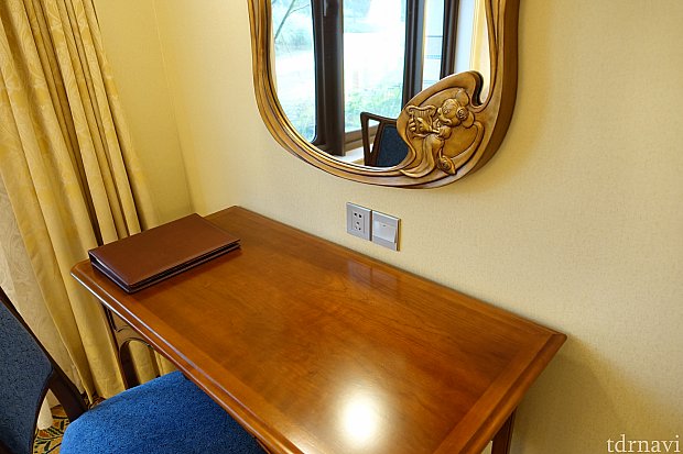 テーブルのそばには鏡とコンセントがあります。イスはフカフカです。