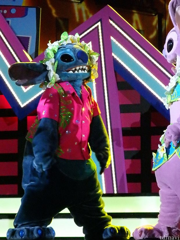 マックスライブにて。
メインの中央ステージで踊らない時、他のキャラクターは左右のステージに移動して踊ったり遊んだりしています。
これは、レイが被れる事に気づいたスティッチが、ふざけてエンジェルやダンサーさんに見せている時ですw