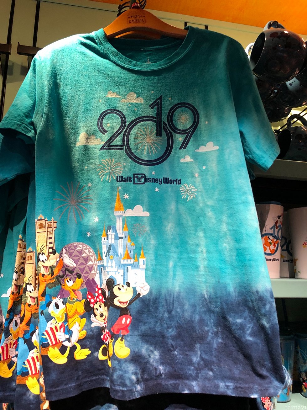 それでは、先ずアパレル系アイテムからご紹介していきましょう。このTシャツは色が鮮やかで目を引かれました。WDWのランドマークが入っているのがWDWらしくて良いですね!$34.99