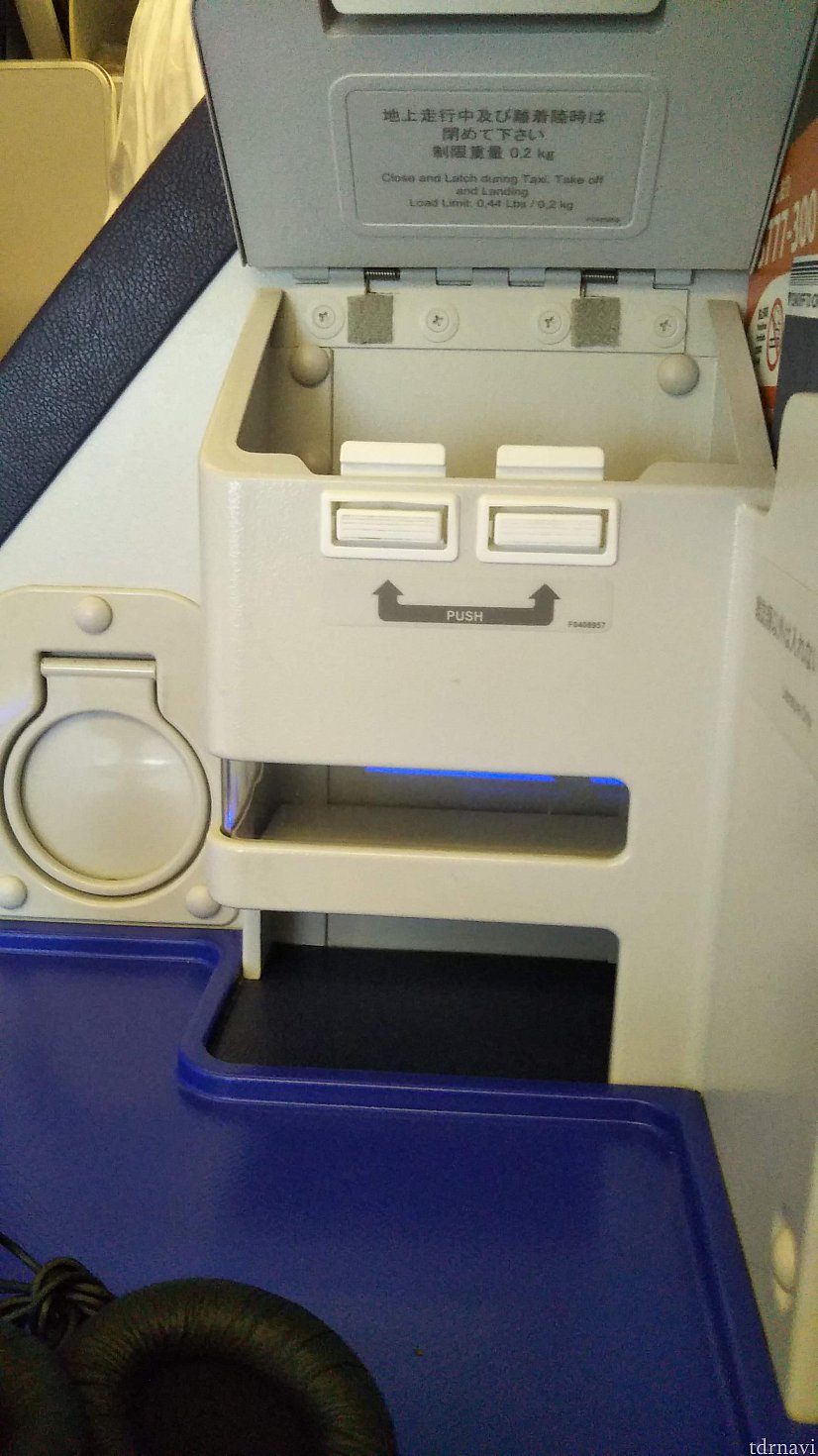 小物入れは、四角い2つのボタンみたいなのを押すと空きます。
しっかり閉まっているのでガチャガチャならずに便利。
眼鏡とスマホ入れになる。
機内はスッピン眼鏡に限りますなぁ!