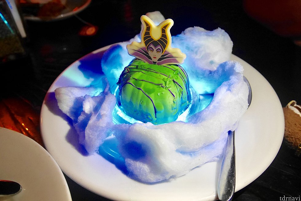 デザートはマレフィセントムースです。中はチョコが入ってました。半端なく甘いです。
色は緑に写ってますが真っ青❗️部屋が暗いので綺麗な色でとれませんでした。2枚ほど色が出てたのですが、緑になってました。
下の白いふわふわのはコットンキャンデー綿あめです。光っているのは色の変わるライトが置いているからです。
このライトは持って帰れます。