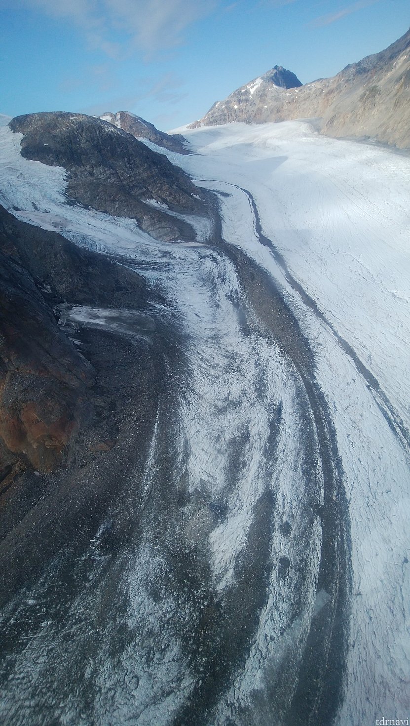 氷河のシマ模様、崩れた岩石が氷河上に溜まり、氷河の流れと共に少しずつ下流に流れていくためできるそうです。